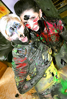 Two pretty hot clothed girls playing with loads of paint