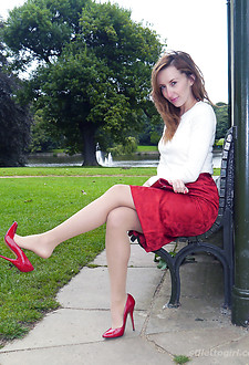 Hot red head Sophia steps out the office on her lunch break to parade around the park in a sexy blouse, red skirt and killer red stiletto heels